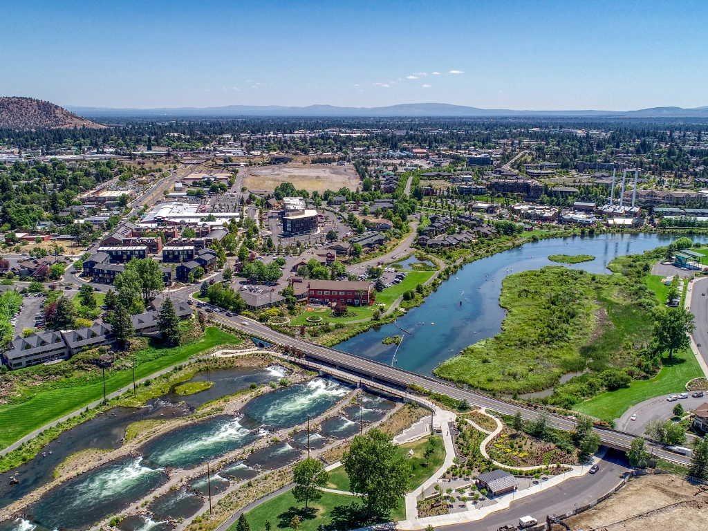 Aerial view of Bend, Oregon — the Deschutes Whitewater Park and river bend with the city behind